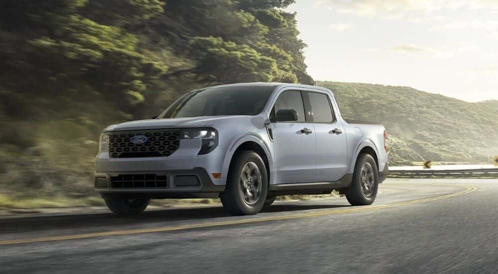 Grey 2026 Ford Maverick XLT driving on a windy road.