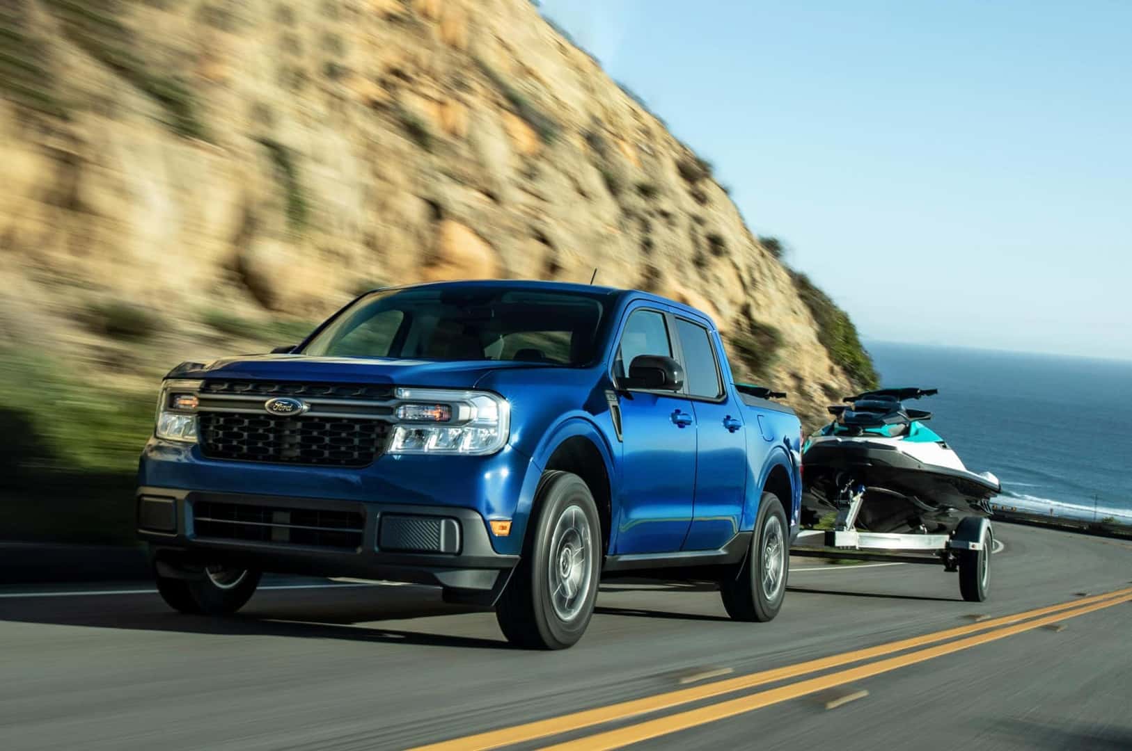 Blue Ford Maverick driving uphill while towing boat