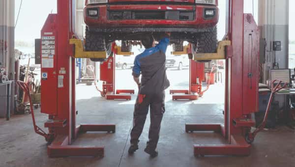 New Ford F-150 raised up on a life with a mechanic working on the powertrain