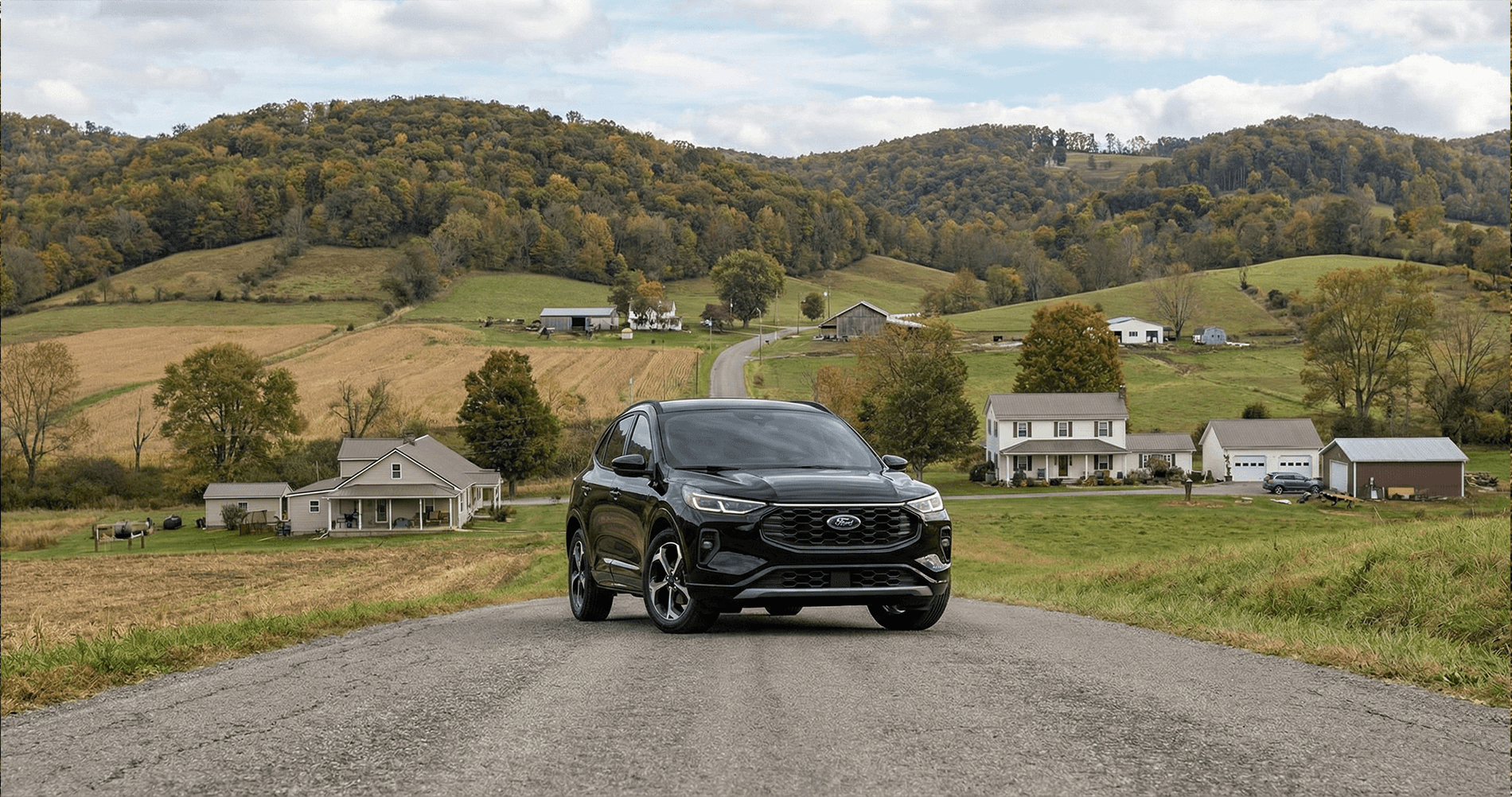 A 2026 Ford Escape lineup parked in an outdoor setting, showing multiple trim levels side by side with distinct colors and styling differences, positioned on a paved overlook with mountains and trees in the background.