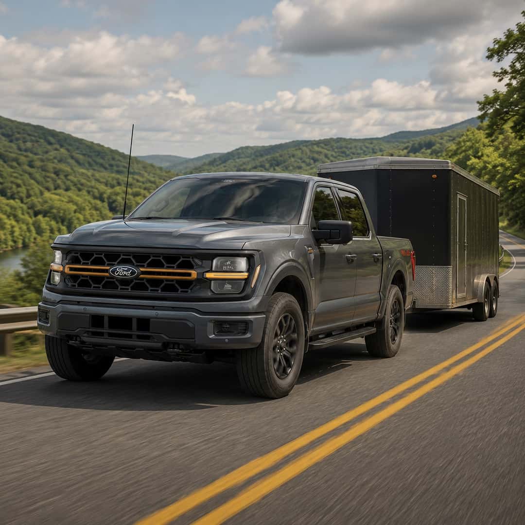 2026 Ford F-150 towing an enclosed trailer on a scenic road near White Hall, West Virginia.