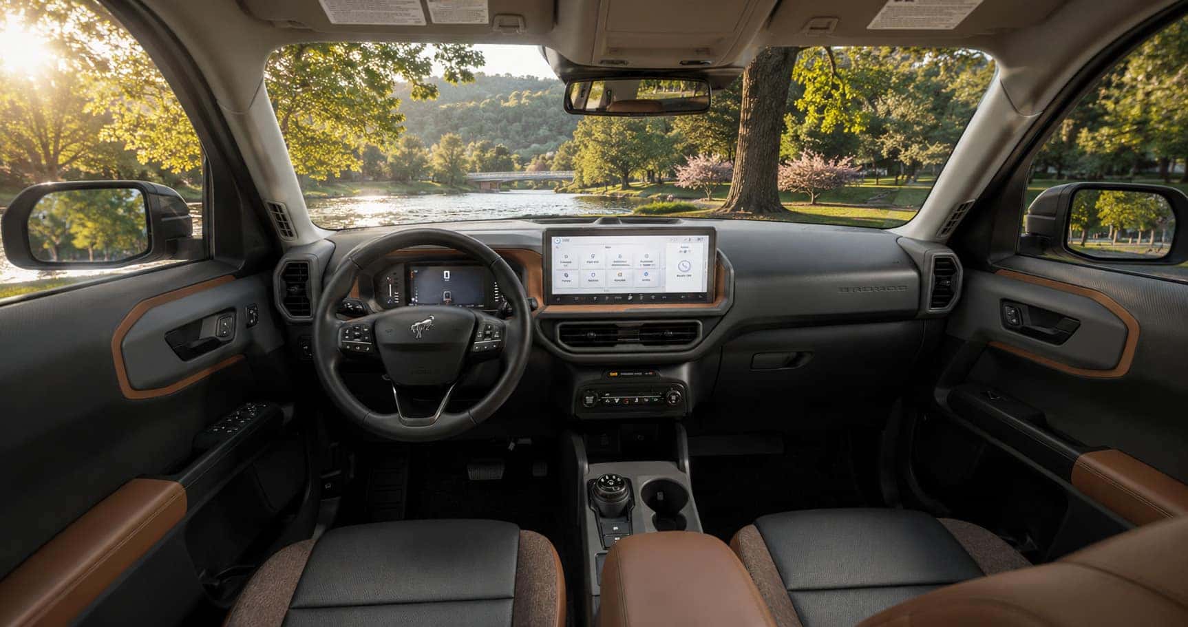 Brown and gray Ford Bronco Sport cabin with touchscreen display and leather seats emphasizing comfort and modern design.