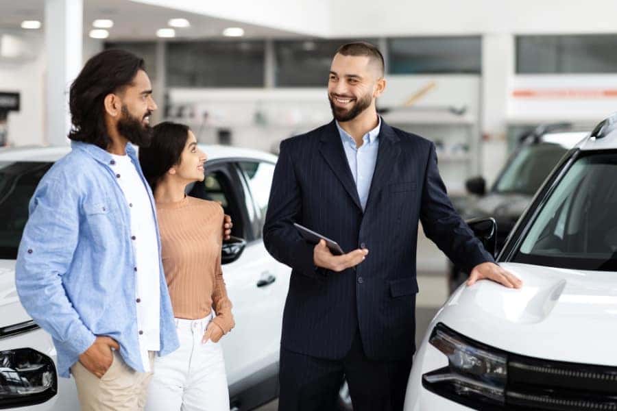 car salesman talking to couple