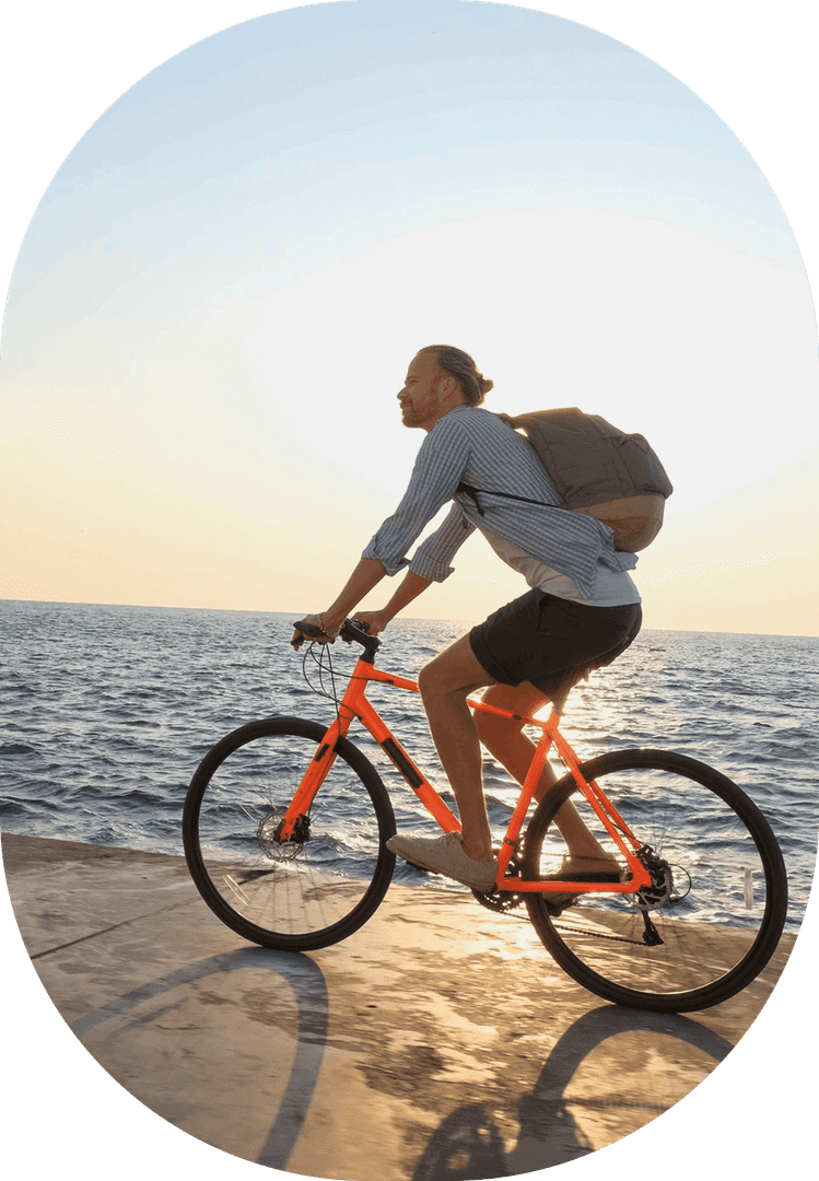 man riding bike in front of water
