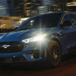 2023 Ford Mustang Mach-E driving with its headlights turned on
