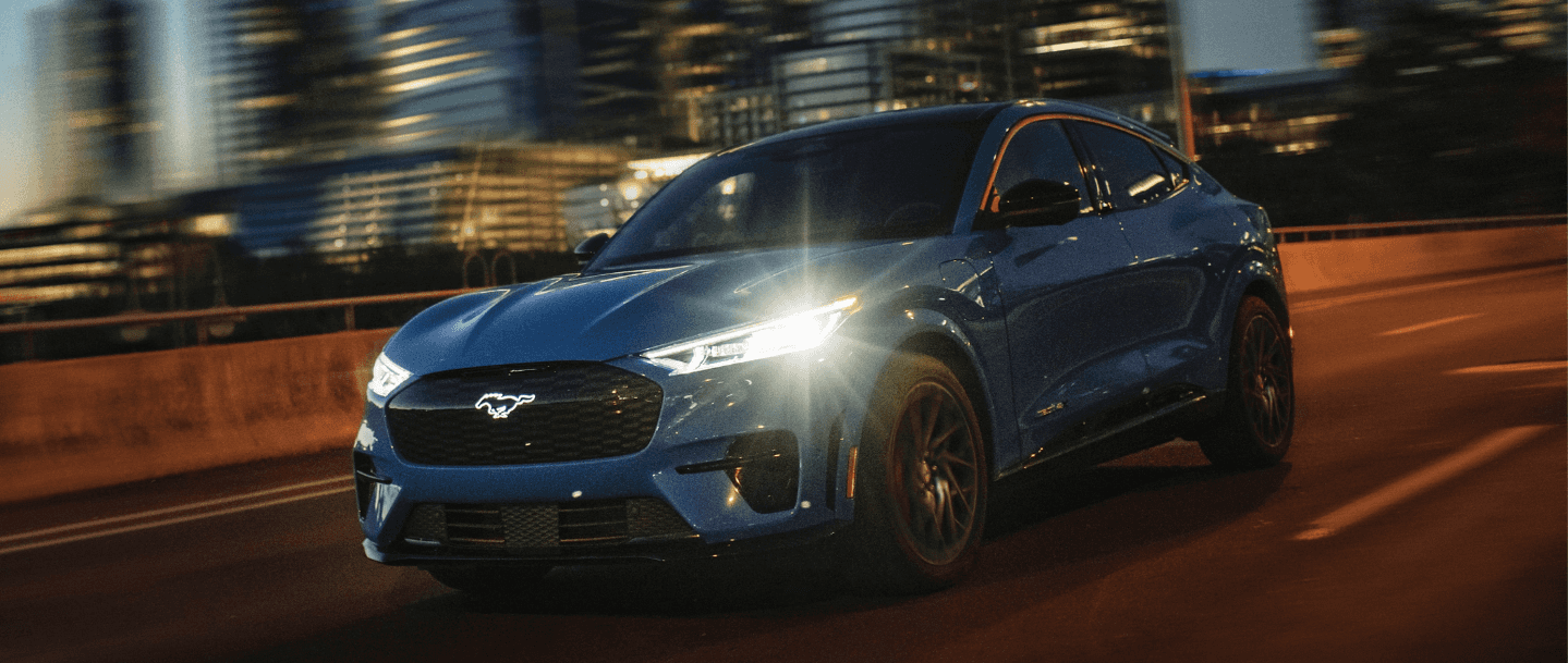 2023 Ford Mustang Mach-E driving with its headlights turned on