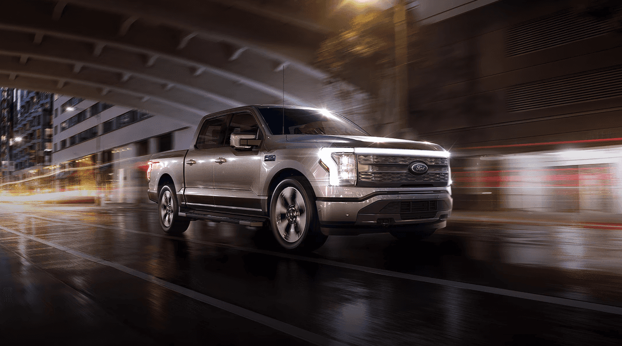 2024 Ford F-150 Lightning driving under an underpass with its headlights on