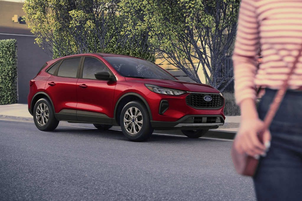 The 2025 Ford Escape parallel parked by a curb with a person walking in the foreground