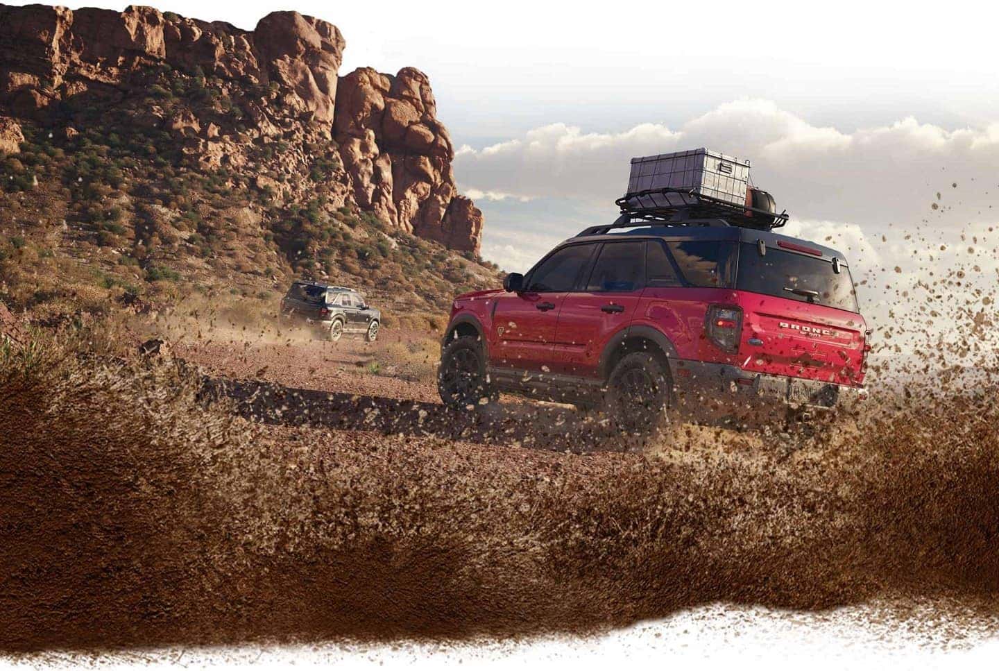 A red 2025 Ford Bronco Sport kicking up mud and dirt while off-roading