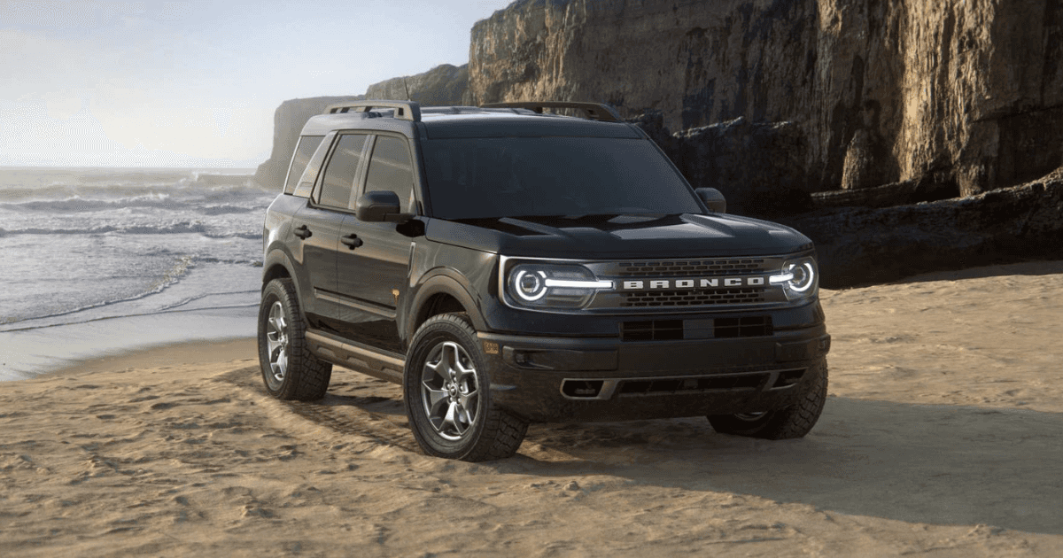 A black Ford Bronco parked on a beach