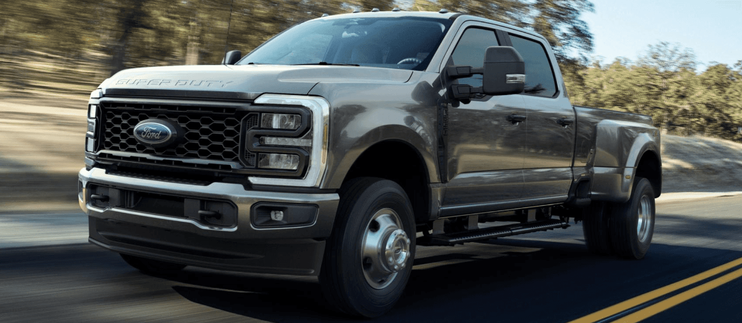 A gray Ford F-350 driving quickly down the road
