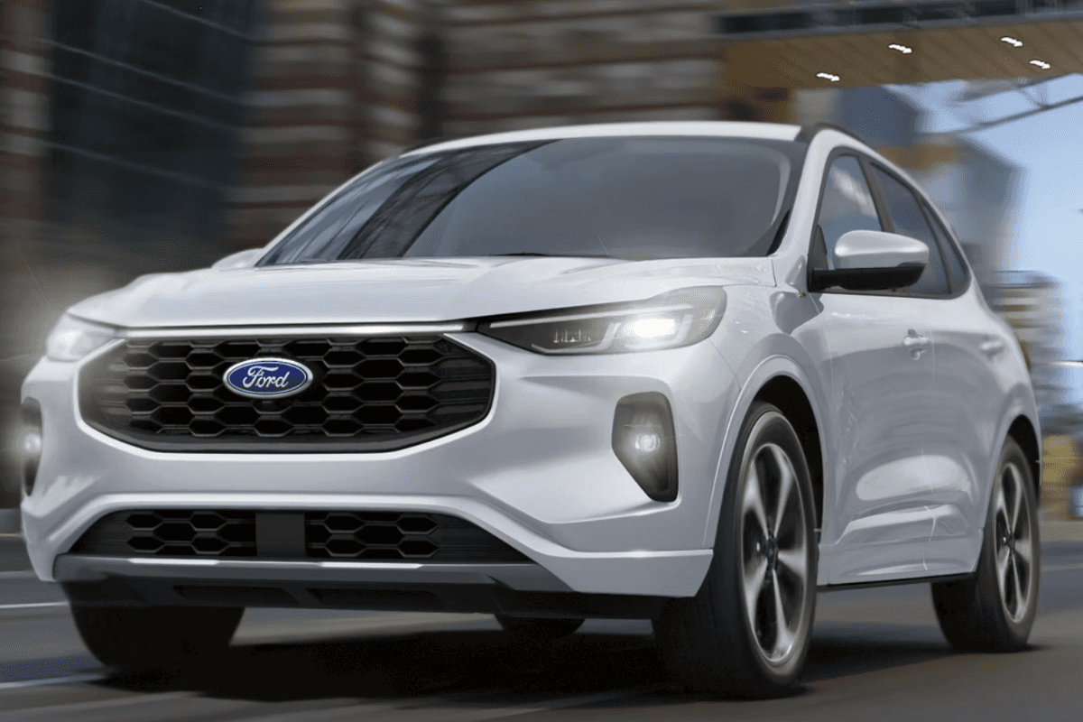 A silver Ford Escape driving down the road through a city