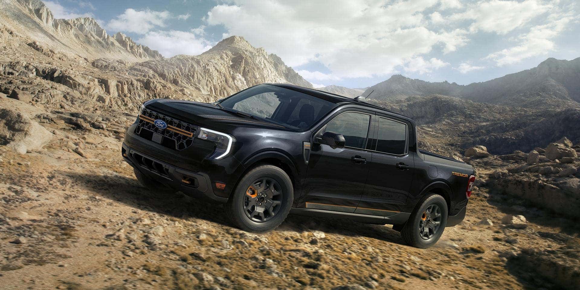 A black Ford Maverick driving up a hill on uneven ground