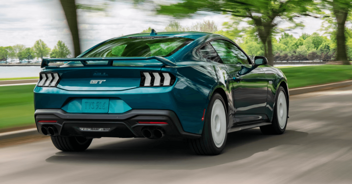 A rear image of a teal Ford Mustang driving down the road