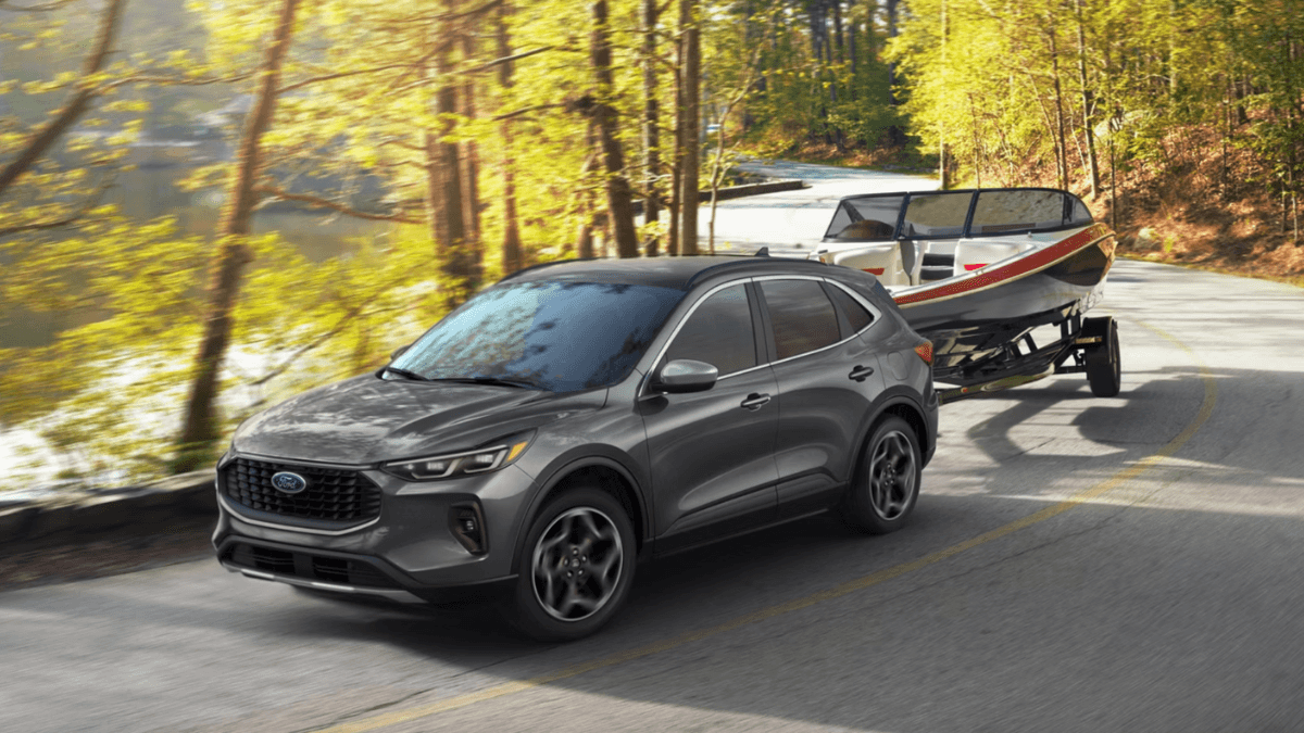 2026 Ford Escape towing a boat on a curved road
