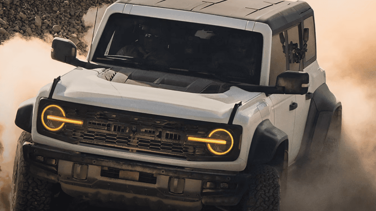 A white Ford Bronco kicking up dust as it drives off-road