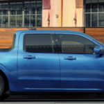 A blue Ford Maverick in profile, parked by the curb