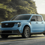 A light blue Ford Maverick driving around a bend in the road next to a cliff