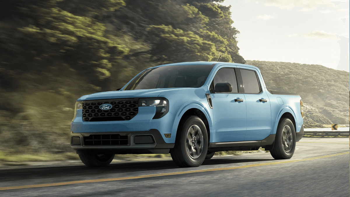 A light blue Ford Maverick driving around a bend in the road next to a cliff