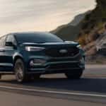 A blue car driving on a road