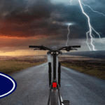 A bicycle on a road with lightning in the background