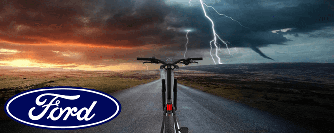 A bicycle on a road with lightning in the background