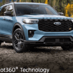 A blue car parked on rocks by a river