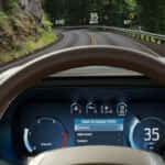 Two hands holding steering wheel on a highway