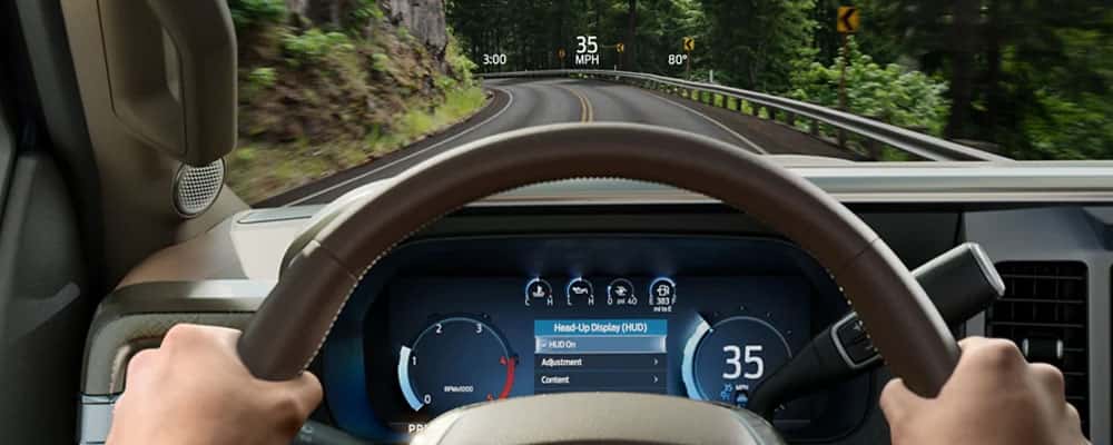 Two hands holding steering wheel on a highway