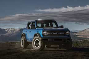 A blue SUV on a dirt road