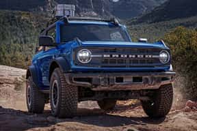 A blue SUV on a dirt road