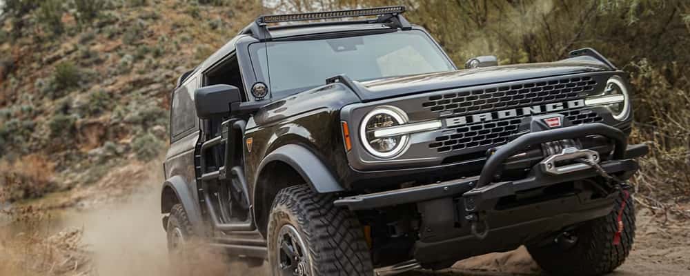 A black SUV driving on a dirt road