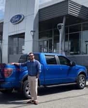 Person standing by a blue truck