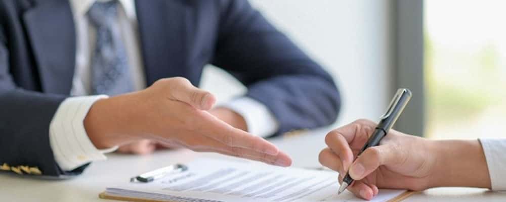 Hand pointing to paperwork.