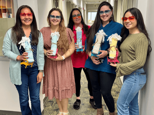 A group of women holding colorful objects