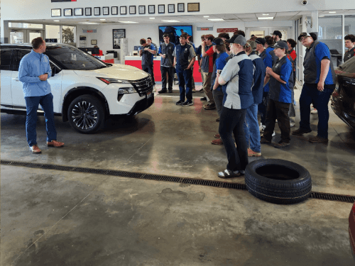 A group of people standing around a car