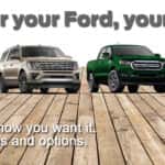 A lineup of Ford models on wooden planks-silver Edge, blue Bronco Sport, gold Expedition, green Ranger, dark blue F-150 and white E-Transit.