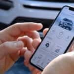 Pair of hands holding cell phone with FordPass on screen.