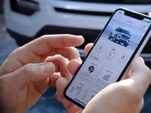 Pair of hands holding cell phone with FordPass on screen.