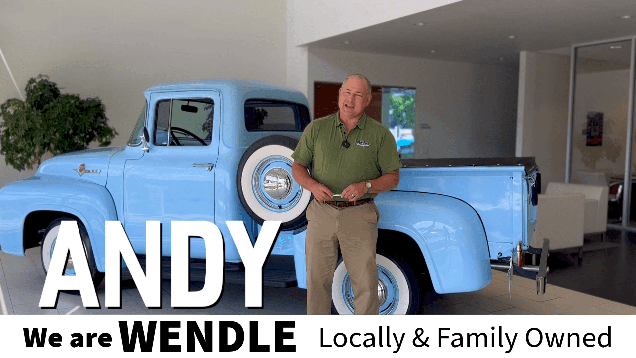 A person standing next to a blue truck