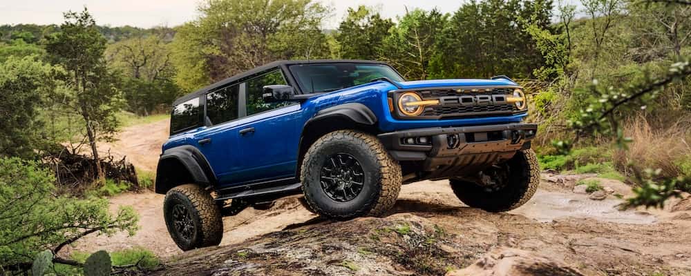 Blue Ford Bronco Raptor on a trail