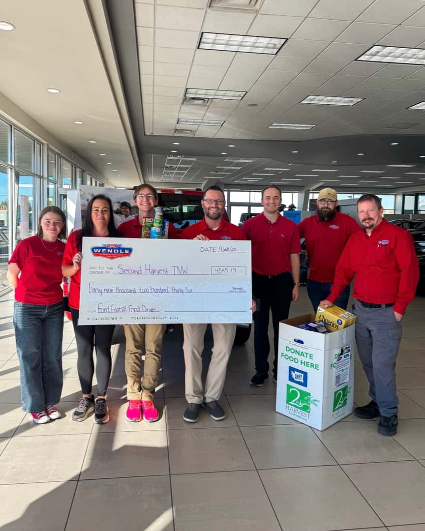 A group of people holding a large check