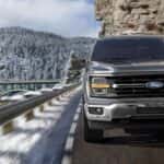 Ford F-150 driving on a snowy mountain road