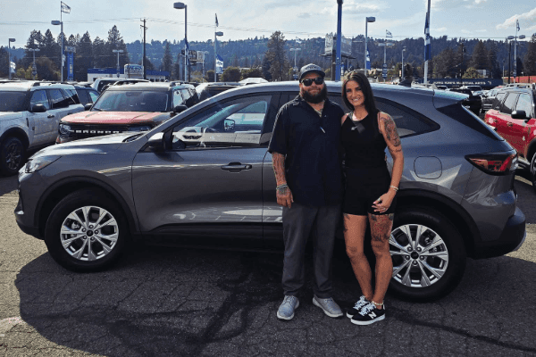 A man and woman standing by a gray new 2025 Ford Escape Active