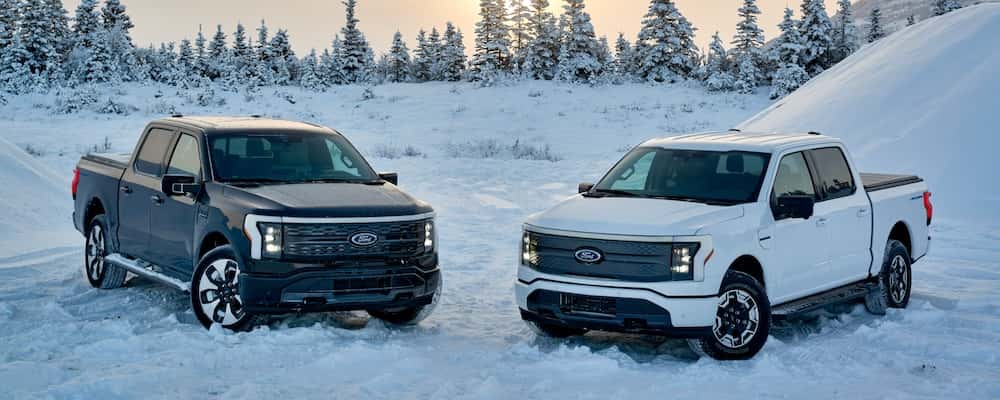 Two Ford F-150 trucks parked in the snow