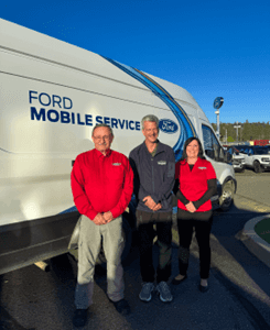 Three members of the Ford Mobile Service team standing in front of a white Ford transit service van at Wendle Ford. Professional on-site vehicle maintenance and repair services.