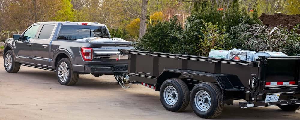 Ford F-150 towing a trailer with landscape supplies