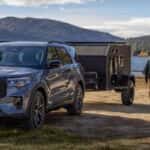 Ford Explorer towing a camper on a lake trip