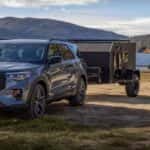 Ford Explorer towing a trailer by the lake
