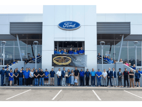 Wendle Ford team gathered outside the dealership building to proudly display and celebrate winning the Ford President's Award.